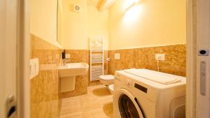 un bagno con lavatrice e WC di Destiny Home & rooms Soave a Soave