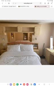 Un dormitorio con una cama grande con sábanas blancas. en Cosy holiday home, en Warden