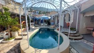 a swimming pool in a courtyard with a building at Niriides Apartments & Studio in Vathi