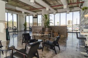 une chambre avec des chaises, des tables et des fenêtres dans l'établissement Hafawah Resort, à Médine