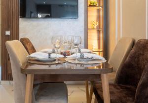 a wooden table with wine glasses on top of it at Charmant et cosy appartement en plein centre ville in Casablanca