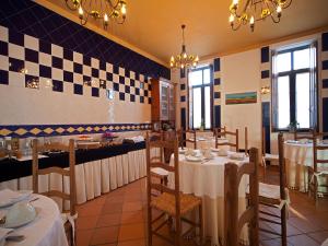 a restaurant with tables and chairs and a checkerboard wall at Betica Hotel Rural in Pias