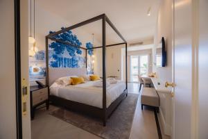 a bedroom with a canopy bed with yellow pillows at Hotel Belvedere in Forte dei Marmi