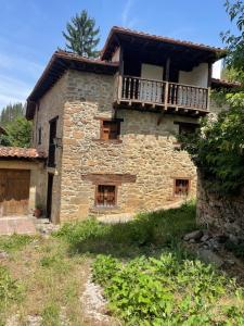 an old stone house with a balcony on top at La Casita in Cabezón de Liébana