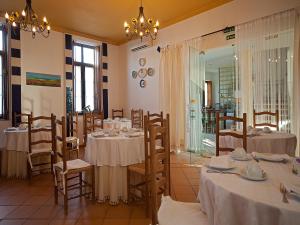 a dining room with tables with white tablecloths at Betica Hotel Rural in Pias