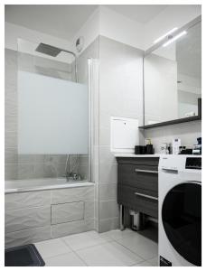 eine weiße Küche mit einer Badewanne und einem Waschbecken in der Unterkunft Paisible 3 pièces, proche de Paris avec parking in Romainville