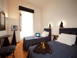 a room with two beds and a laptop on a table at Betica Hotel Rural in Pias
