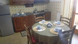 une cuisine avec une table avec deux chaises et un évier dans l'établissement A Casa di Sarina, à Riposto