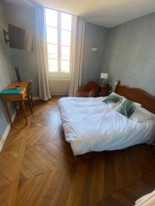 Postel nebo postele na pokoji v ubytování Hôtel des Cymaises