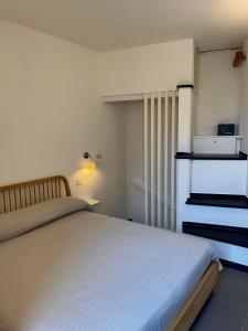 a bedroom with a white bed and a dresser at Nicolina 5 Il Cappero in Vernazza