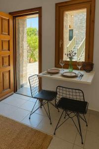 a kitchen with a table and two chairs with wine glasses at Avgonyma Square Nest in Avgonyma