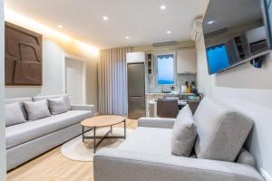 a living room with two couches and a kitchen at Keslin Premium Seaside Apartments in Vlorë