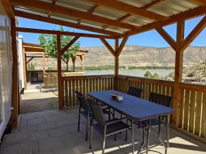 a patio with a blue table and chairs on a deck at Bellavista - Fishingcamp in Mequinenza