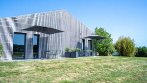 un edificio con due ombrelli neri su un campo di Les Villas du Parc de la Chabotterie a Saint-Sulpice-le-Verdon