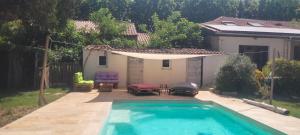 Una piscina en un patio trasero con un dosel sobre ella. en Gite LA DEPENDANCE, en Le Cailar