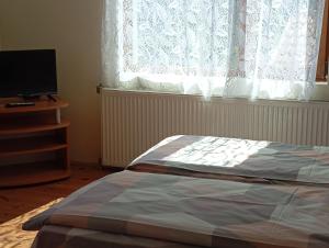 a bedroom with a bed and a window with a television at Къща за гости ЧЕРИ in Tryavna +9 photos