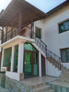 a house with a staircase and a balcony at Къща за гости ЧЕРИ in Tryavna