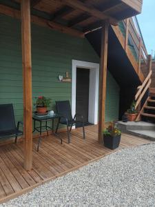 a wooden deck with two chairs and a table at Lili stuudio in Otepää