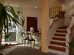 a room with a table and chairs and a staircase at Betica Hotel Rural in Pias