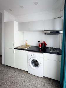 a white kitchen with a washing machine in it at Pura Vida Mamaia Nord 2-vila exclusivista cu 3 apartamente individuale in Năvodari +11 photos