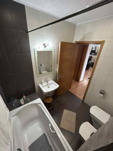 a bathroom with a bath tub and a sink at Alojamento Luna in Porto Judeu