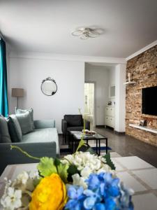 a living room with a couch and a table with flowers at Pura Vida Mamaia Nord 2-vila exclusivista cu 3 apartamente individuale in Năvodari