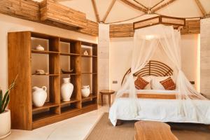 a bedroom with a bed with a mosquito net at Nuanu Suites & Accommodations in Tabanan