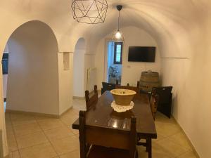 a dining room with a table and chairs and a tv at Trulli Pinnacoli in Locorotondo