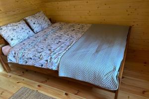 a bed in a room with a wooden wall at Domek z balią in Zwierzyniec