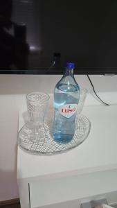 a bottle of water sitting next to a glass on a table at Mk house in Estoril +3 photos