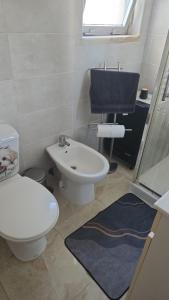 a bathroom with a white toilet and a sink at Mk house in Estoril