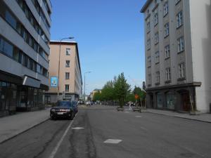 a car is driving down a city street with buildings at Anne's City Apartment in Jyväskylä