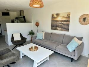 una sala de estar con un sofá y una mesa en Vakantie Zeeland, en Brouwershaven