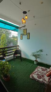 a living room with a green carpet and a couch at Kanakdhara Homestay in Ujjain