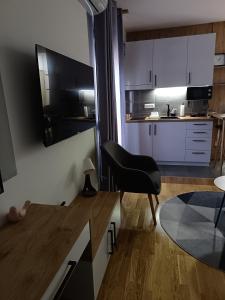 eine Küche mit einem schwarzen Stuhl und einem Tisch in der Unterkunft Orca Apartman in Jagodina