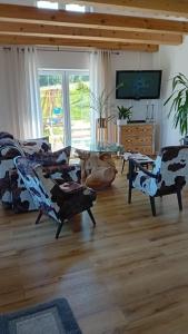 a living room with chairs and a table and a television at Domek Kaprys Piatkowa in Piątkowa