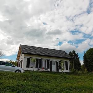 a white house with a car parked in front of it at Domek Kaprys Piatkowa 