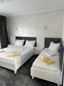 two beds in a room with towels on them at Casa George in Costinesti