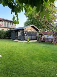 a building in a yard with a green lawn at Casa George in Costinesti