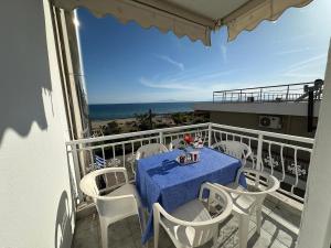 a table and chairs on a balcony with the ocean at Nikos Apartment in Paralia Dionysiou