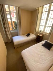 Postel nebo postele na pokoji v ubytování Hôtel des Cymaises