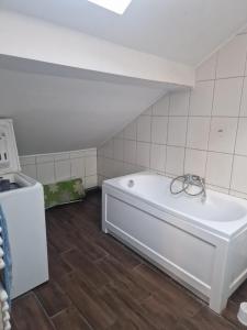 a bathroom with a white tub in a attic at Apartament Pracowniczy in Pogórze