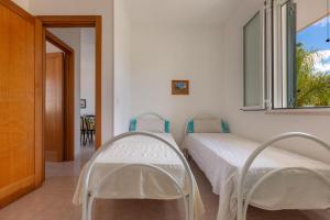 zwei Betten in einem Zimmer mit Fenster in der Unterkunft Villino Raffy by BarbarHouse in Torre dell'Orso