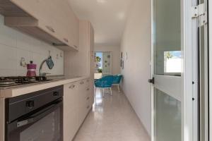 eine weiße Küche mit Spüle und Herd in der Unterkunft Villino Raffy by BarbarHouse in Torre dell'Orso + 22 Fotos