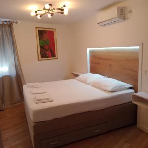 a bedroom with a large bed with a wooden headboard at VILA ROZA in Prožura
