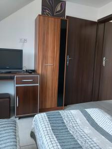 a bedroom with a bed and a cabinet and a tv at Adria in Sarbinowo