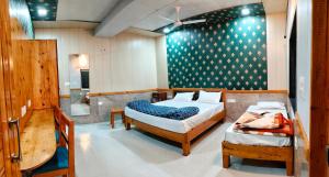 a bedroom with two beds and a bath room at Tmboos Homes in Patwa Dunga