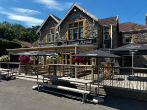a restaurant with benches and umbrellas in front of a building at Room above the Inn in Bristol