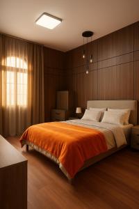 a bedroom with a large bed with an orange blanket at YODA Luxe Appartment, Yasmin-village in Ras al Khaimah +11 photos