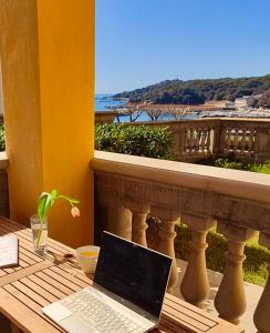 a laptop computer sitting on a table on a balcony at Appartamenti fronte mare in Castiglioncello